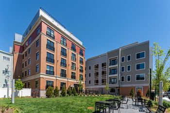a courtyard with tables and chairs in front of an apartment building at Union 346, Somerville, MA, 02143